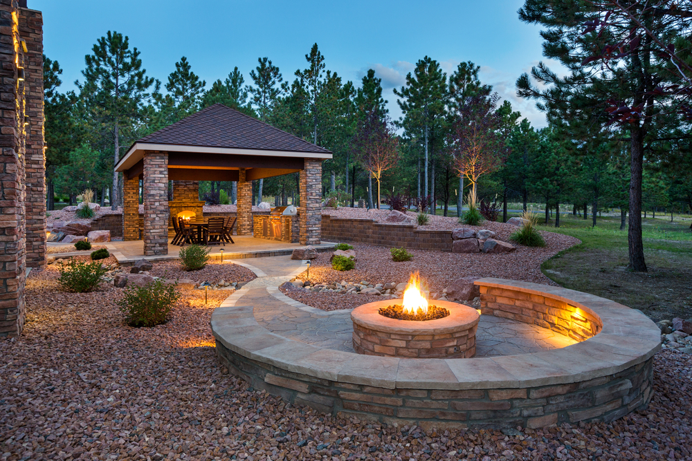 Stone outdoor seating space with fire pit and gazebo in Leander, TX