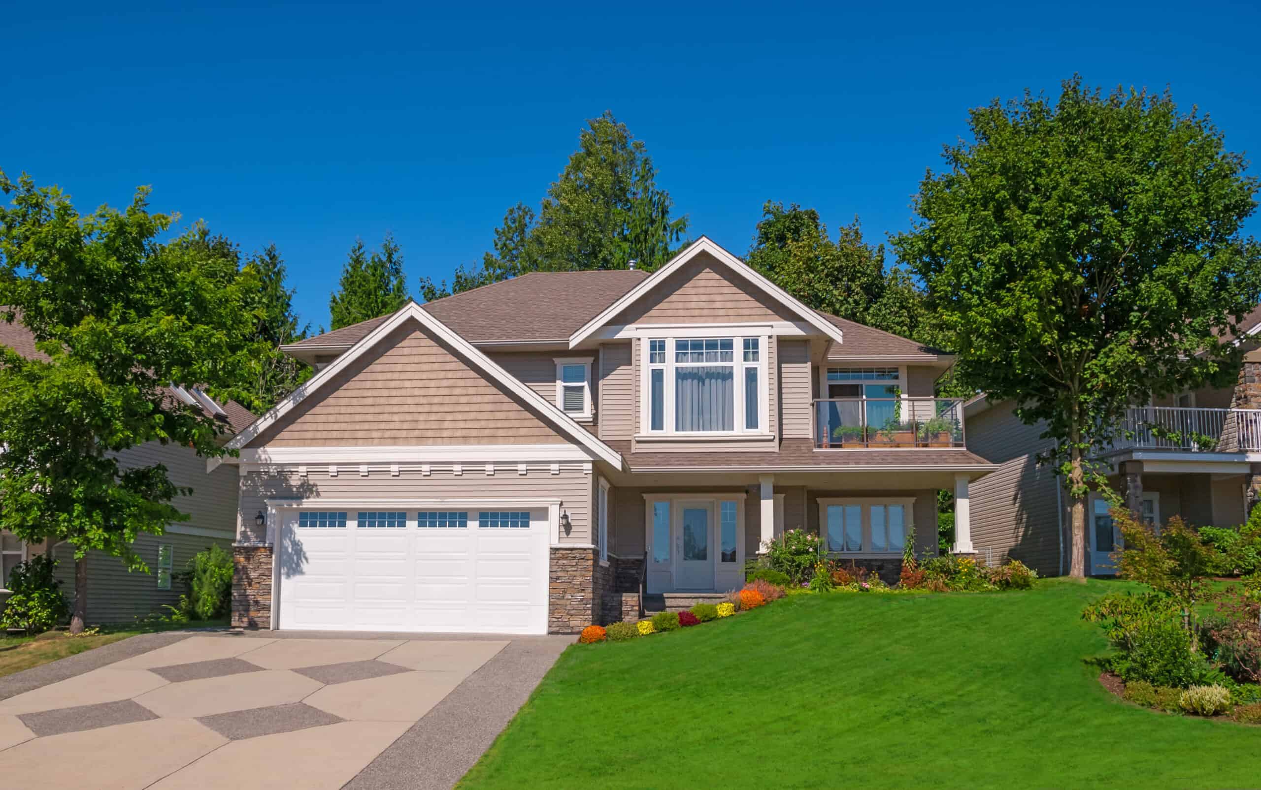 a beautiful modern house with a stamped concrete driveway leading to a one-stall garage