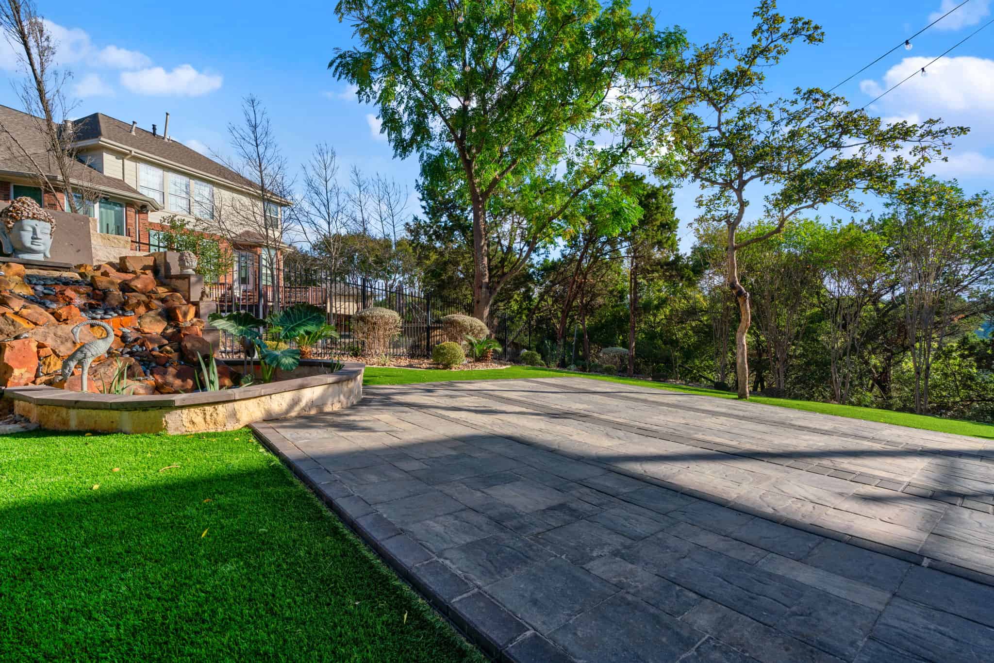 spacious backyard paver patio with retaining wall seating and open layout ideal for gatherings and outdoor entertaining.