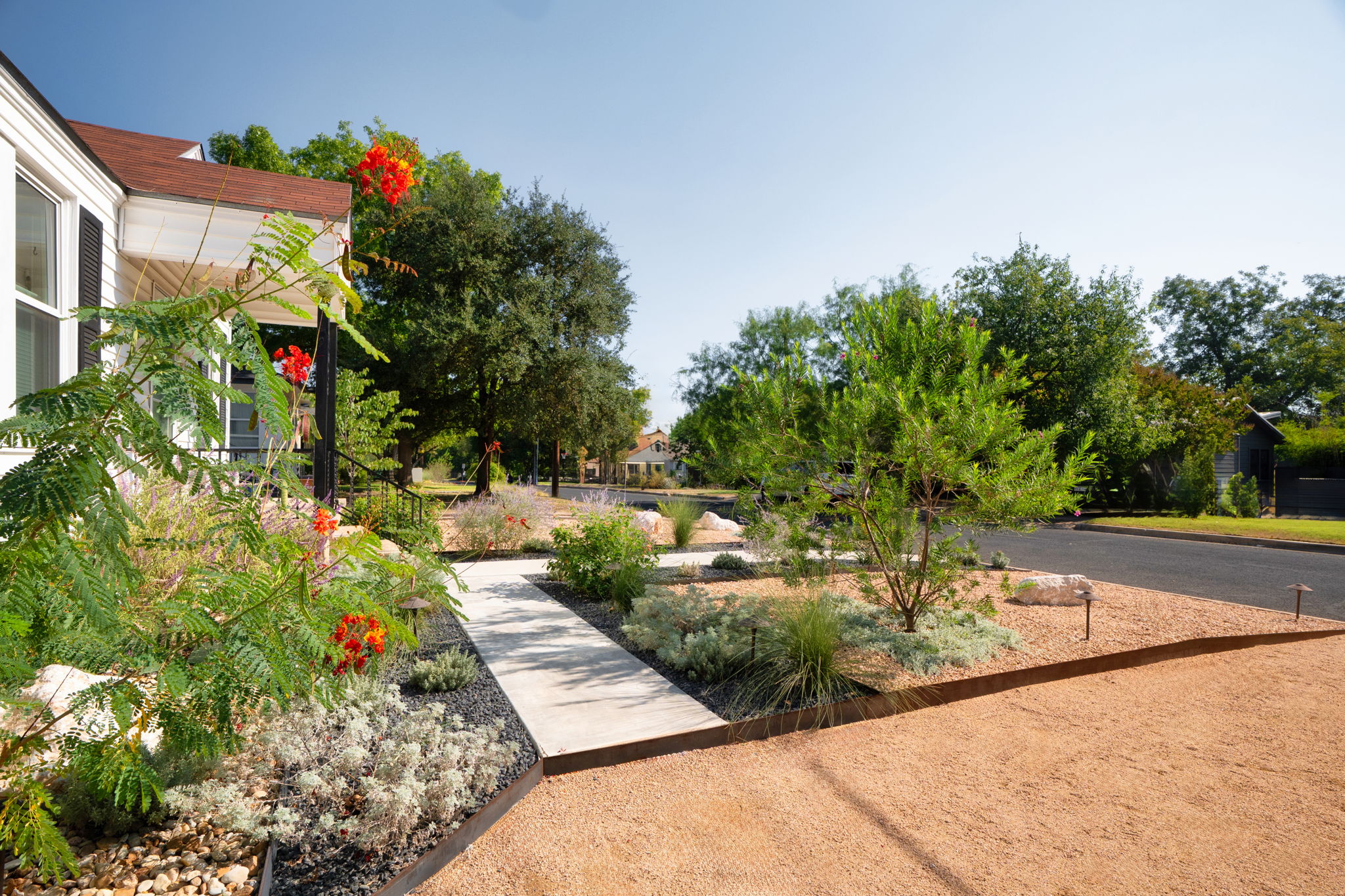 Modern front yard with drought-tolerant plants and gravel showcasing efficient irrigation installation for water-smart landscaping.